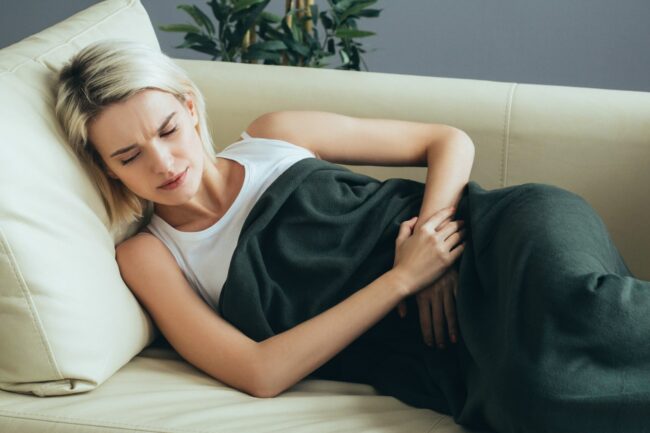 woman lying down wanting cbd for pms symptoms